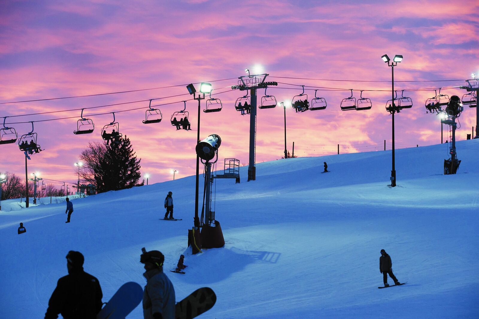 Skiers and snowboarders ride the slopes during a cloudy sunset at Wilmot Mountain in December 2018. (Alyssa Pointer/Chicago Tribune/TNS)