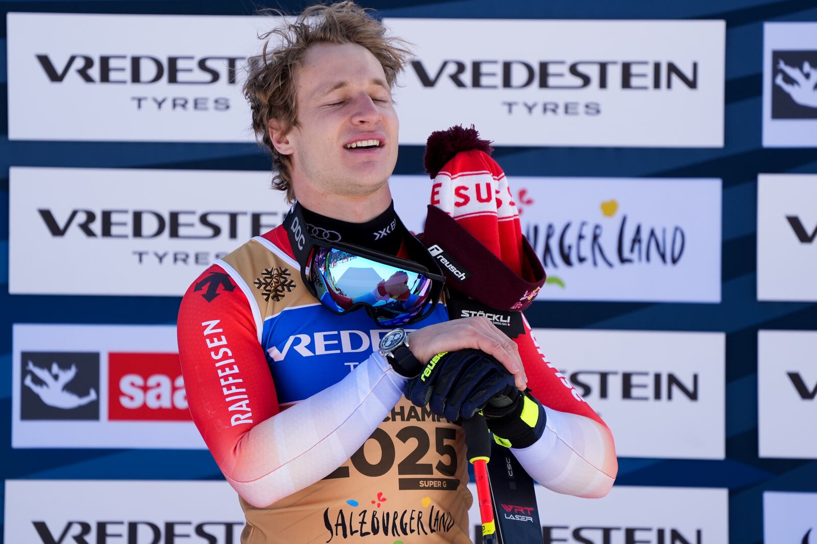 Switzerland's Marco Odermatt listens to the national anthem on the podium after winning the gold medal in a men's Super-G, at the Alpine Ski World Championships, in Saalbach-Hinterglemm, Austria, Friday, Feb. 7, 2025. (AP Photo/Giovanni Auletta)