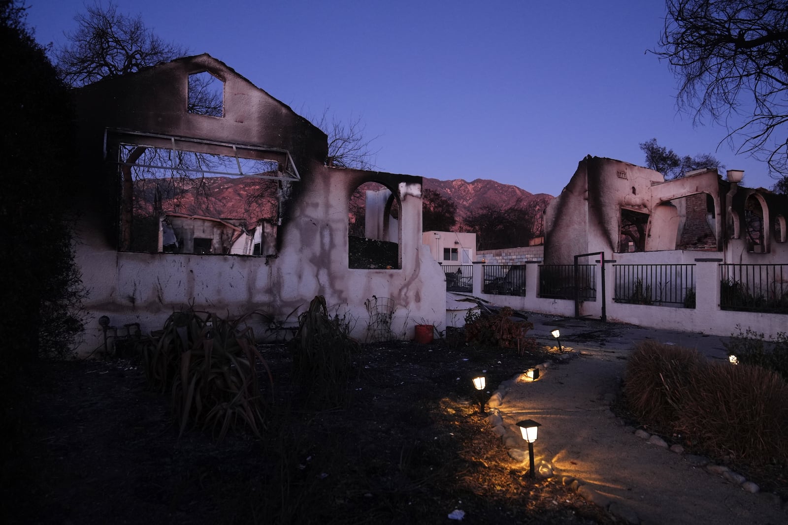 Solar lights remain on outside a home destroyed by the Eaton Fire, Tuesday, Jan. 14, 2025, in Altadena, Calif. (AP Photo/Jae C. Hong)