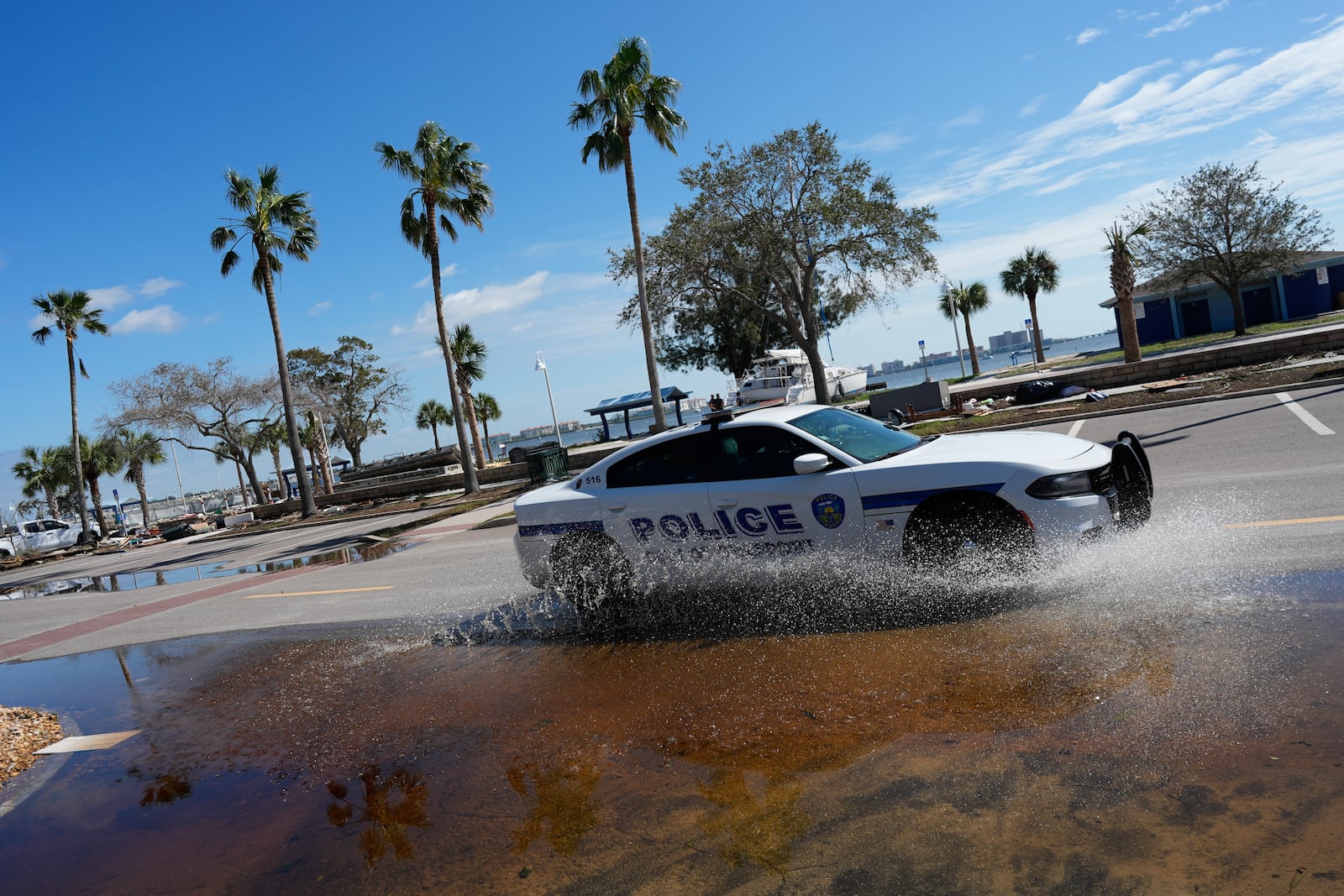 A police car patrols along a lightly flooded street following the passage of Hurricane Milton, in Gulfport, Fla., Thursday, Oct. 10, 2024. (AP Photo/Rebecca Blackwell)