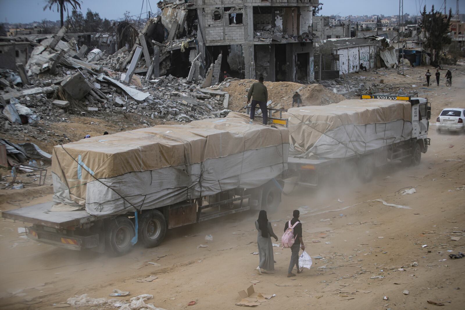 Humanitarian aid trucks enter through the Kerem Shalom crossing from Egypt into the Gaza Strip, in Rafah, Wednesday, Jan. 22, 2025, days after the ceasefire deal between Israel and Hamas came into effect. (AP Photo/Jehad Alshrafi)