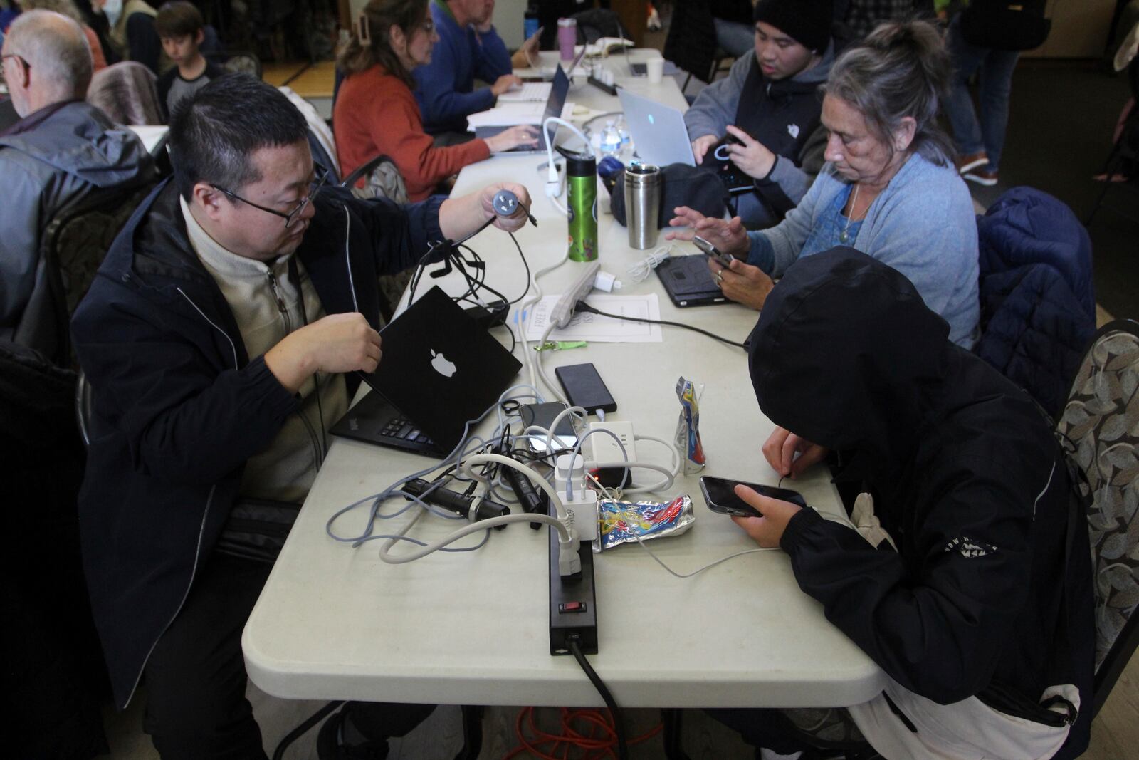 People charge their electronics at a charging station set up at the Issaquah Senior Center in Issaquah, Wash., Friday, Nov. 22, 2024. (AP Photo/Manuel Valdes)