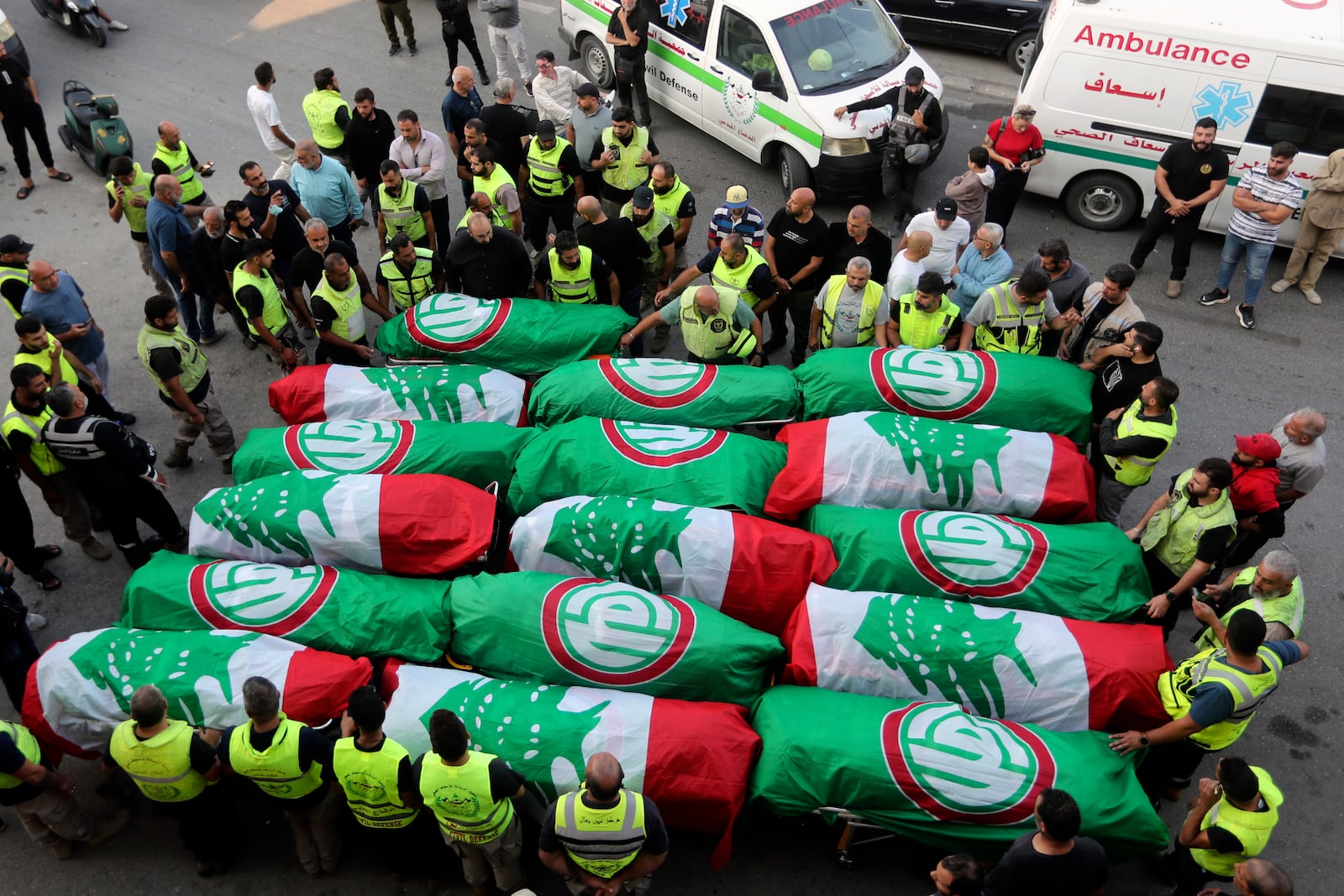 FILE - Paramedics stand next to the coffins of people who were killed in an Israeli airstrike in Barja, during their funeral procession in Tyre, southern Lebanon, on Nov. 7, 2024. (AP Photo/Mohammed Zaatari, File)