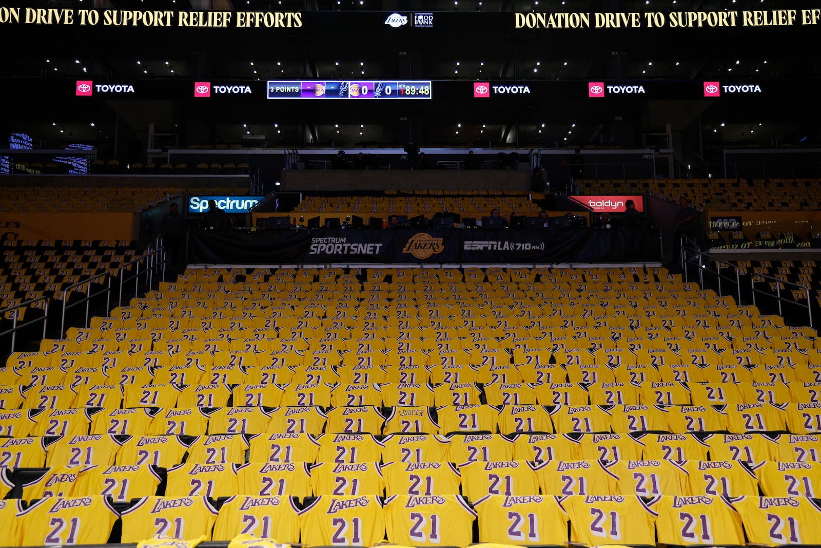 Jerseys with the number of former Los Angeles Lakers player Michel Cooper are left for fans on seats before an NBA basketball game between the Lakers and the San Antonio Spurs, Monday, Jan. 13, 2025, in Los Angeles. Cooper's No. 21 jersey will be raised into the rafters during halftime. (AP Photo/Kevork Djansezian)