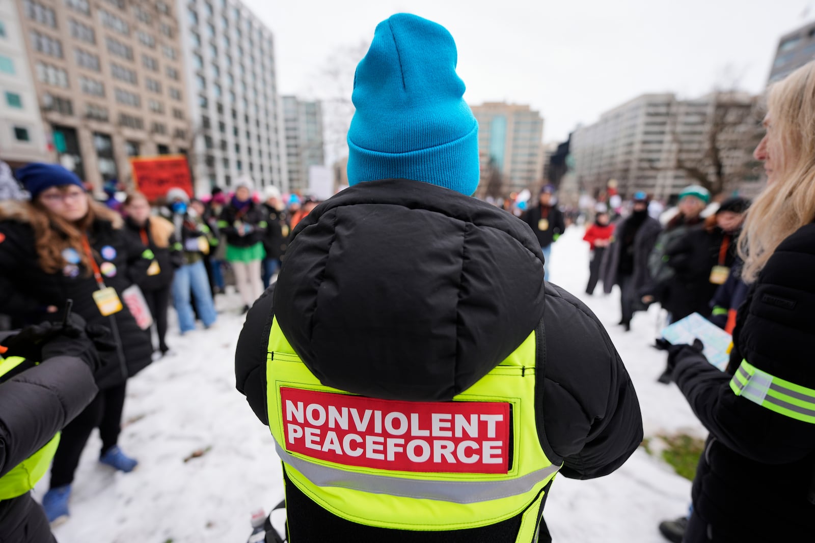 A volunteer speaks to others in Farragut Square before the start of the People's March, Saturday, Jan. 18, 2025, in Washington. (AP Photo/Mike Stewart)