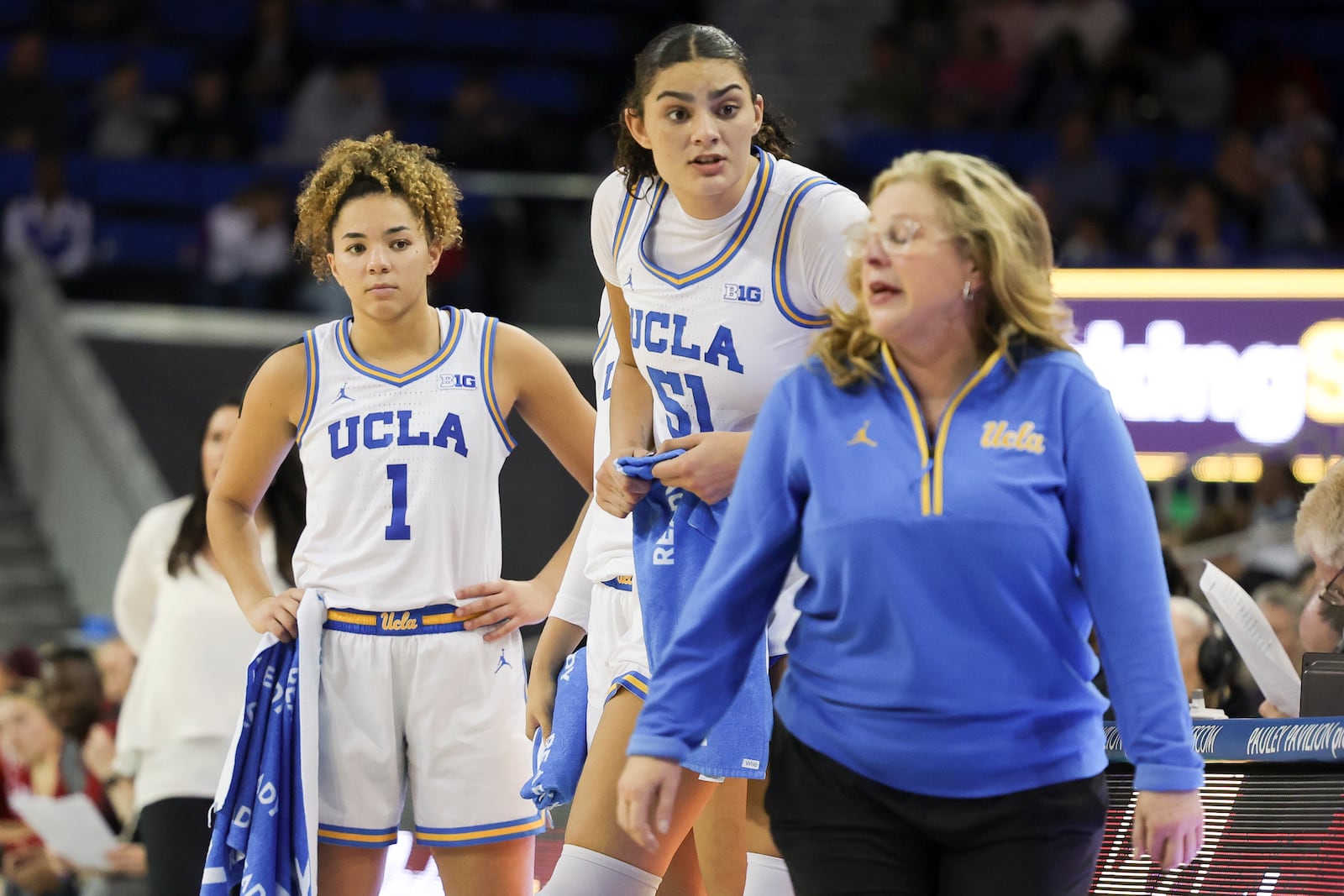 UCLA guard Kiki Rice, left, and center Lauren Betts, center, speak with head coach Cori Close during the second half of an NCAA college basketball game against Nebraska Sunday, Dec. 29, 2024, in Los Angeles. (AP Photo/Ryan Sun)