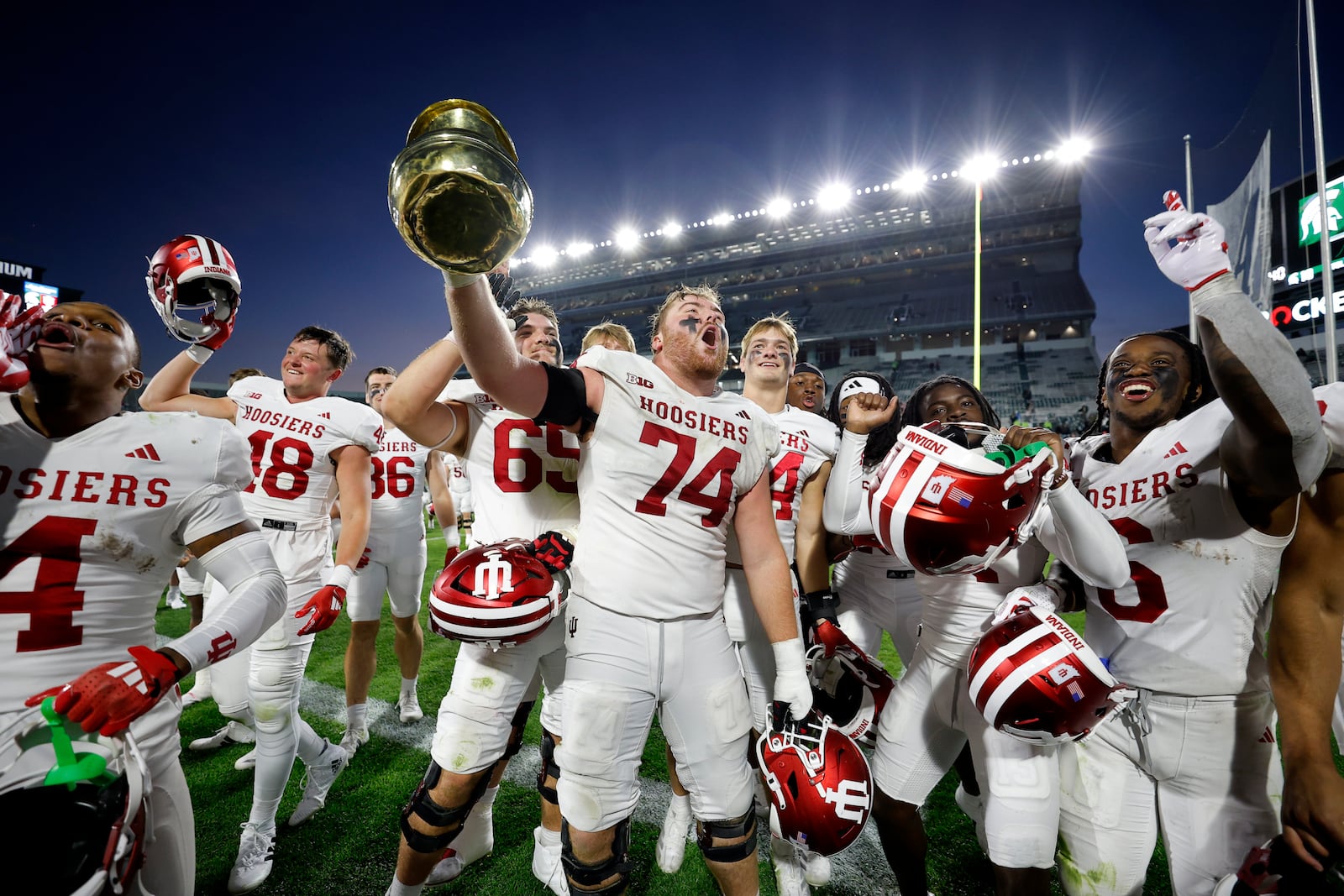 Indiana players, including offensive lineman Bray Lynch (74), celebrate with the Old Brass Spitoon after defeating Michigan State in an NCAA college football game, Saturday, Nov. 2, 2024, in East Lansing, Mich. (AP Photo/Al Goldis)