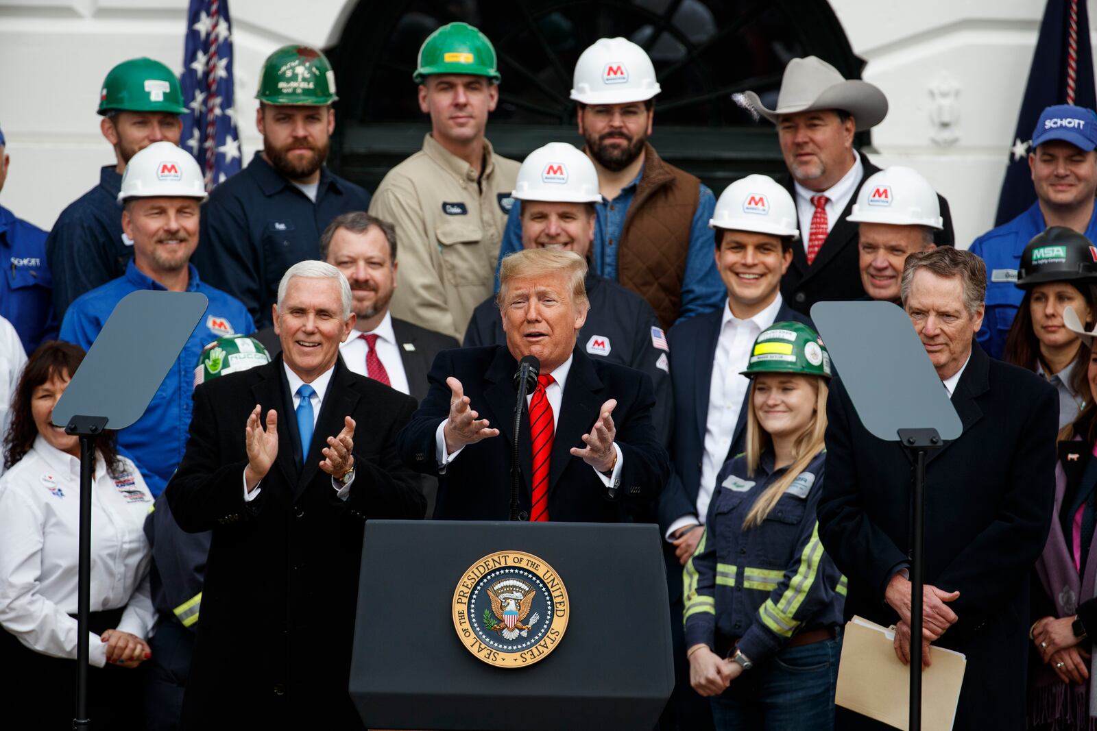 FILE - President Donald Trump speaks during an event at the White House to sign a new North American trade agreement with Canada and Mexico, Jan. 29, 2020, in Washington. The President is joined by Vice President Mike Pence, left, and U.S. Trade Representative Robert Lighthizer, right, and others. (AP Photo/Alex Brandon, File)