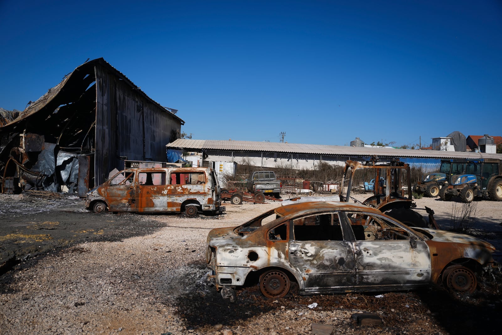 Burned-out cars and buildings from Hezbollah rockets are seen in the agricultural settlement of Avivim, near the Lebanese border in the Upper Galilee, Israel, on Monday Dec. 2, 2024. Despite the ceasefire with Hezbollah, Israelis remain wary of returning to the north. (AP Photo/Ohad Zwigenberg)