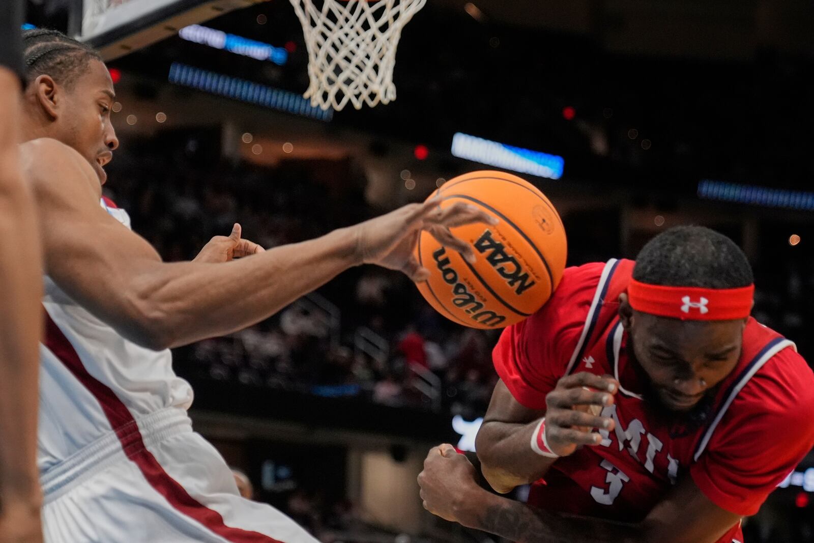 Alabama forward Derrion Reid, left, falls out of bounds in front of Robert Morris guard Amarion Dickerson, right, in the first half in the first round of the NCAA college basketball tournament, Friday, March 21, 2025, in Cleveland. (AP Photo/Sue Ogrocki)