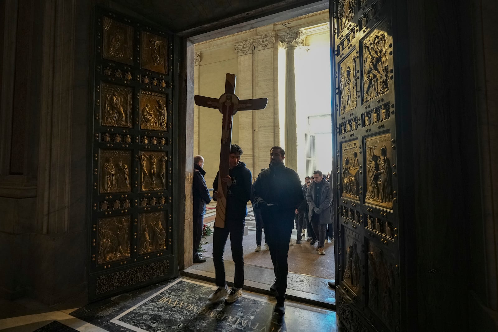 Faithful walk through the Holy Door of St.Peter's Basilica at the Vatican, Wednesday, Dec. 25, 2024, after it was opened by Pope Francis on Christmas Eve marking the start of the Catholic 2025 Jubilee. (AP Photo/Andrew Medichini)