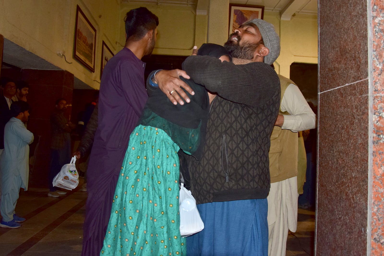 Passengers rescued by security forces from a passenger train attacked by insurgents comfort each other upon their arrival at a railway station in Quetta, Pakistan, Wednesday, March 12, 2025. (AP Photo/Arshad Butt)