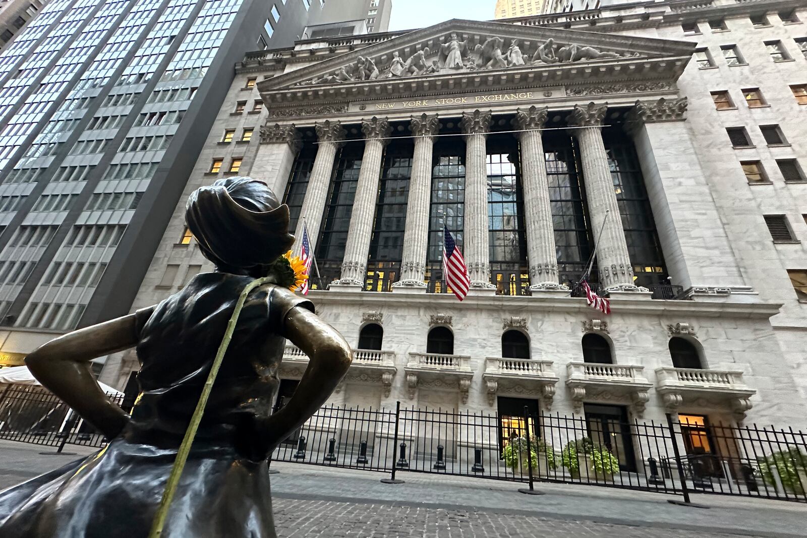 FILE - The Fearless Girl statue, with a flower draped on the shoulder, stands outside the New York Stock Exchange on Oct. 23, 2024. (AP Photo/Peter Morgan, File)