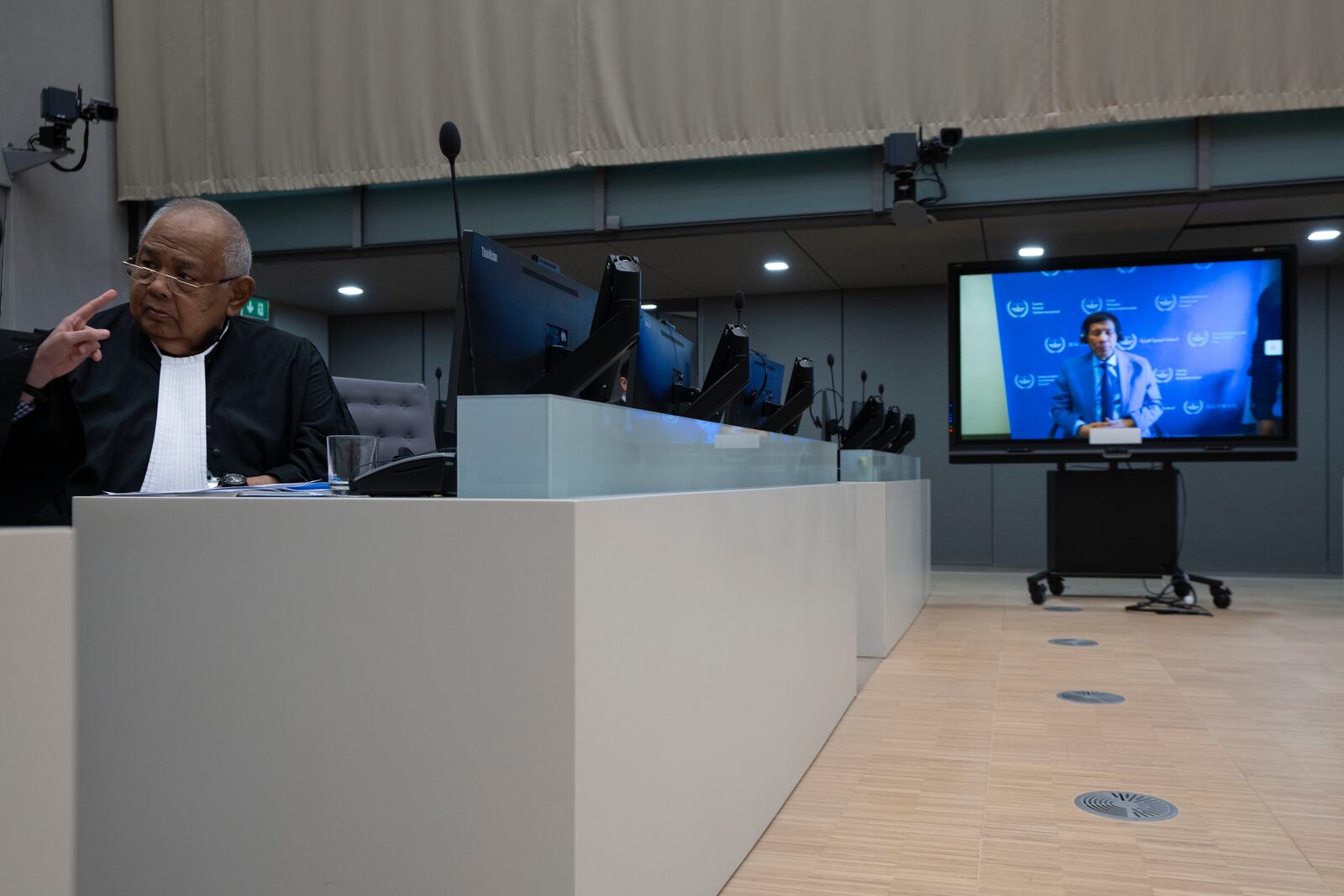 Former Philippine President Rodrigo Duterte is seen on a screen in the courtroom of the International Criminal Court (ICC) with his lawyer Salvador Medialdea seated left, in The Hague, Netherlands, Friday, March 14, 2025. (AP Photo/Peter Dejong, Pool)