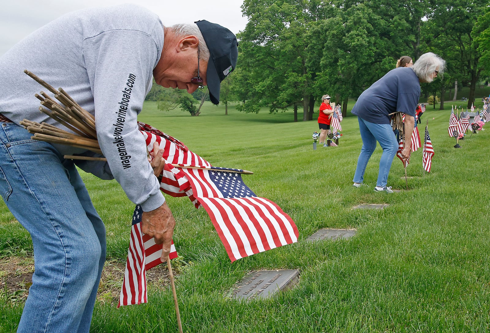 Mike Fogarty joined the volunteers Saturday morning, May 18, 2024 as they placed over 3,000 American flags on the graves of service men and women interred in Ferncliff Cemetery for Memorial Day. Over 40 volunteers, including a large group from Werner Enterprises, placed flags on the central GAR (Civil War) mound, WWI section, WWII section and the Annex with more recent graves. The event was organized by Ferncliff Cemetery and Arboretum. BILL LACKEY/STAFF