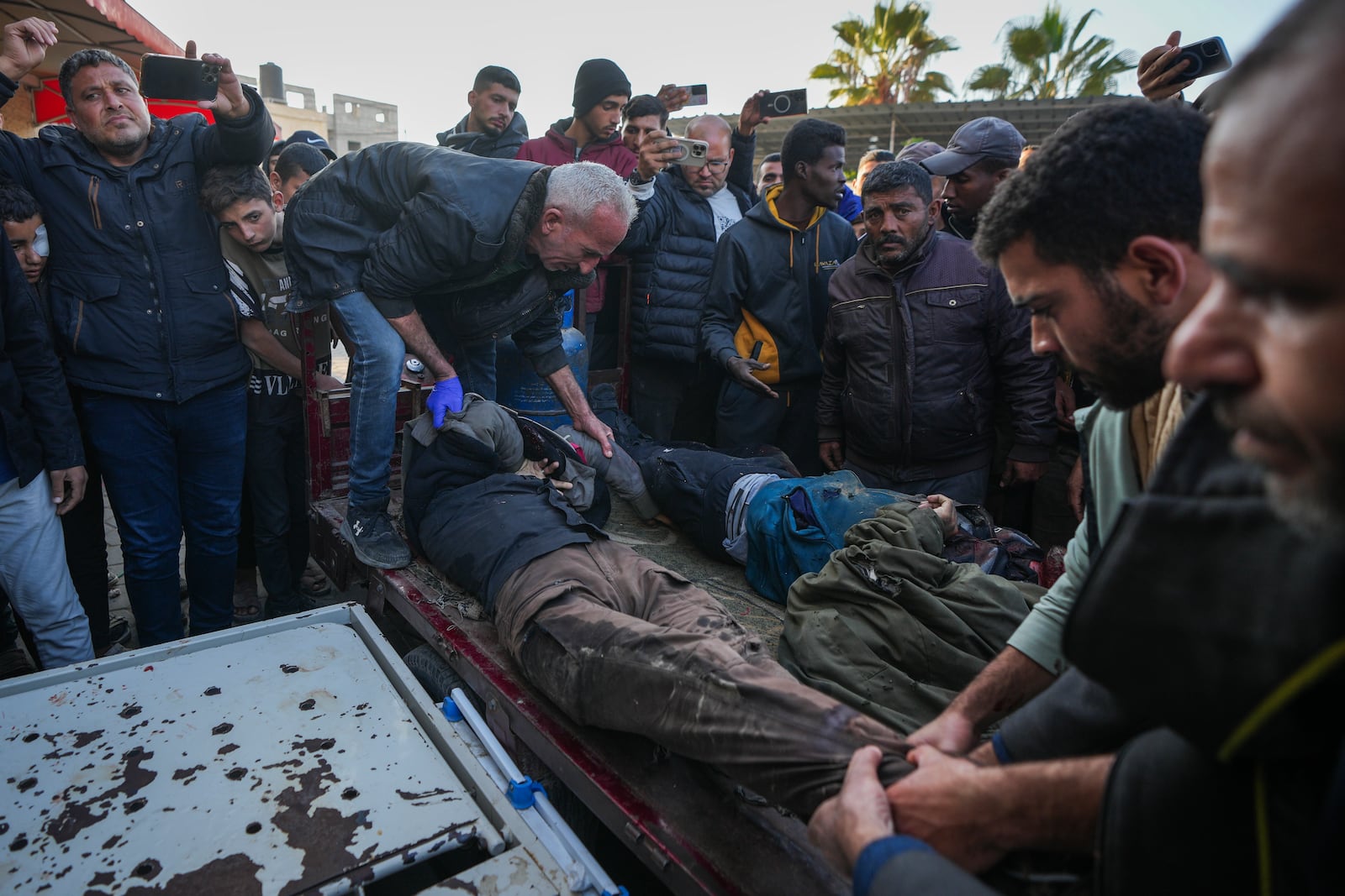 The bodies of four men killed in an Israeli army strike targeting a car are brought to Al-Aqsa Martyrs hospital in Deir al-Balah, central Gaza Strip, Friday, Jan. 3, 2025.(AP Photo/Abdel Kareem Hana)