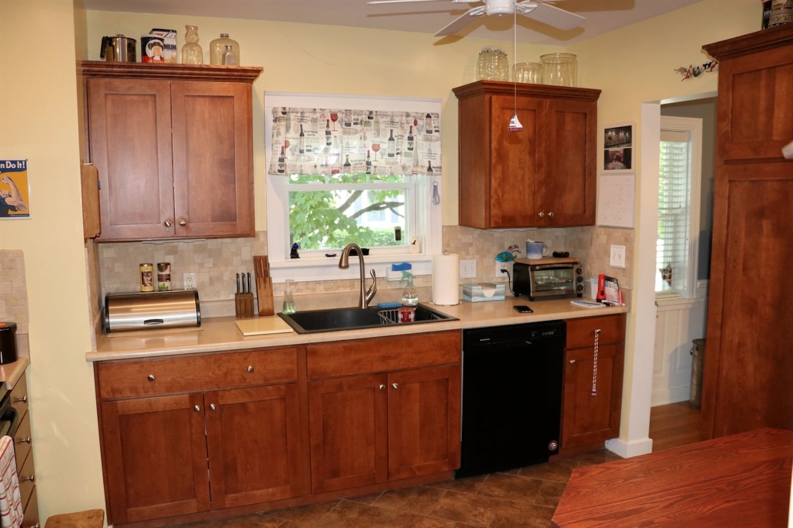 Light cherry Shaker-style cabinetry fills the kitchen wall space. Along one wall is a cabinet, and the space allows for a breakfast nook.