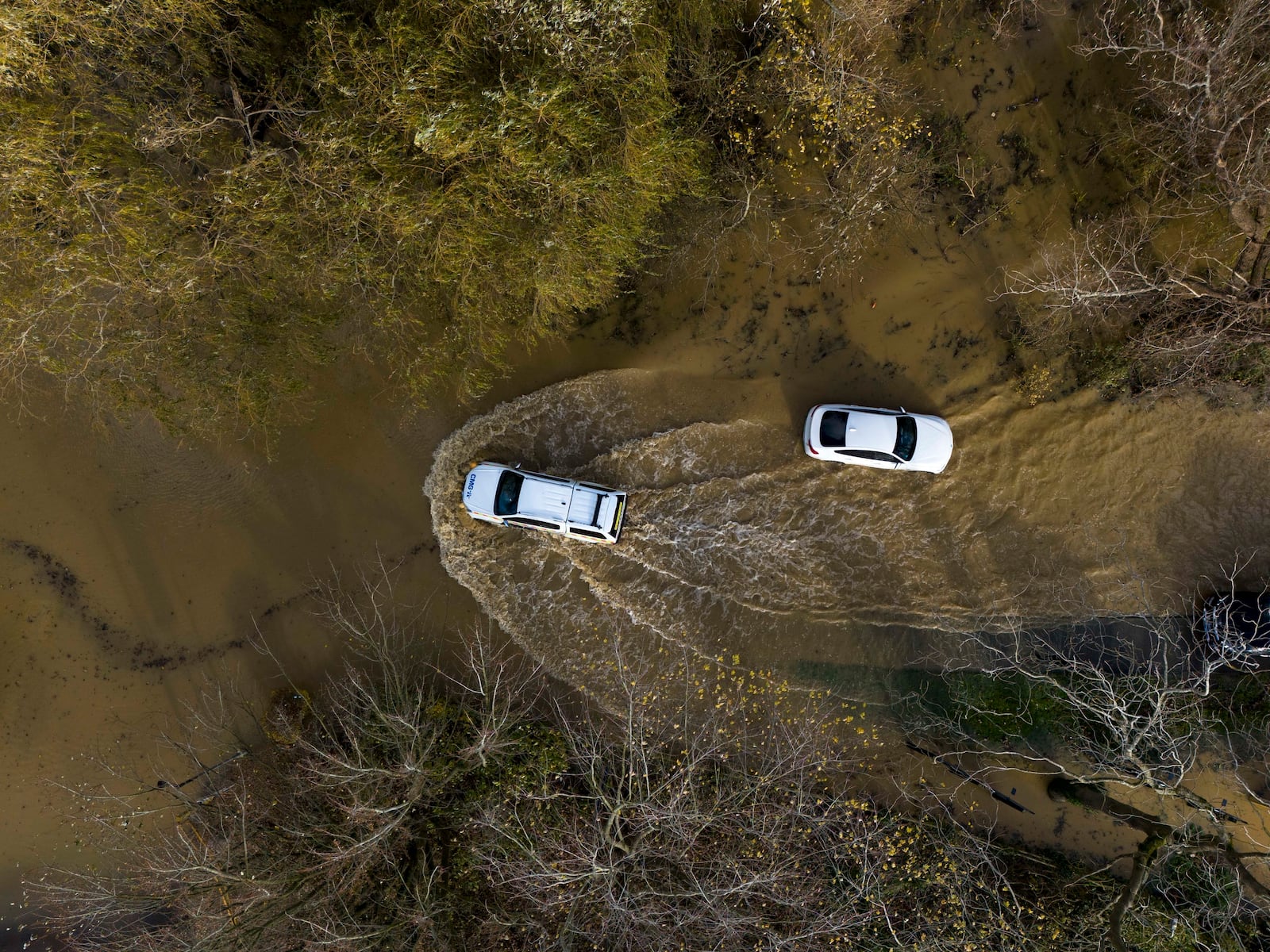 A car drives through floodwater at the Billing Aquadrome in Northamptonshire, England, Monday Nov. 25, 2024, after Storm Bert caused "devastating" flooding over the weekend. (Jordan Pettitt/PA via AP)