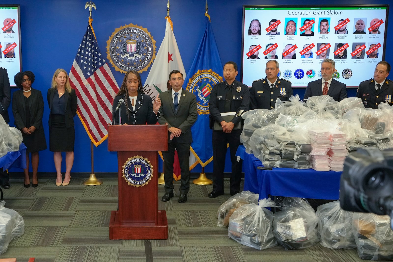 FBI Special Agent in Charge Krysti Hawkins, at podium, joined by federal, local, and international officials, announces federal charges and arrests of alleged members of a transnational drug trafficking operation that routinely shipped hundreds of kilograms of cocaine from Colombia, through Mexico and Southern California, to Canada and other locations in the United States, during a news conference at the FBI offices in Los Angeles, Thursday, Oct. 17, 2024. (AP Photo/Damian Dovarganes)