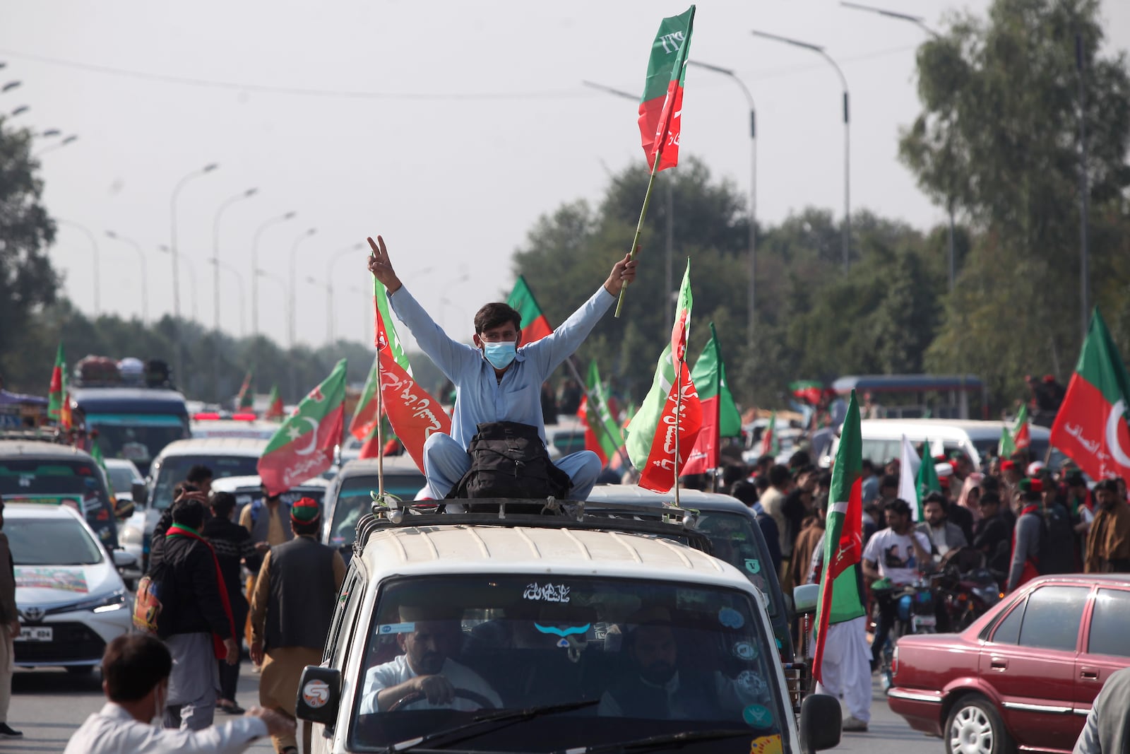 Supporters of imprisoned former premier Imran Khan's Pakistan Tehreek-e-Insaf party, board into vehicles as they starting a rally for Islamabad to demand Khan's release, in Peshawar, Pakistan, Sunday, Nov. 24, 2024. (AP Photo/Muhammad Sajjad)