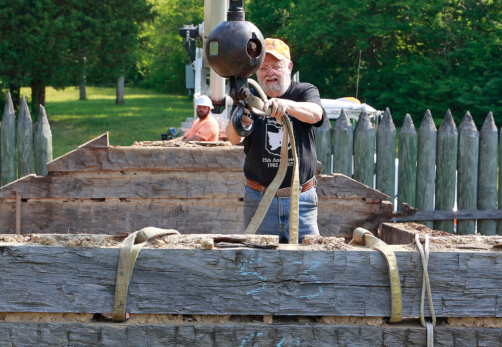 Jim Campbell attaches a crane to one of the logs that make up the log cabin at George Rogers Clark Park Friday, June 9, 2023. The cabin, which was built in 1974, is being disassembled to repair some of the damage caused by decades of exposure to the weather. Jim Campbell was part of the crew that built the cabin nearly 50 years ago. BILL LACKEY/STAFF