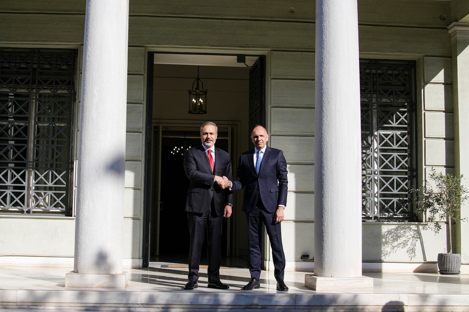 Greek Foreign Minister George Gerapetritis, right, welcomes his Turkish counterpart Hakan Fidan before their meeting in Athens, Greece, Friday, Nov. 8, 2024. (AP Photo/Thanassis Stavrakis)