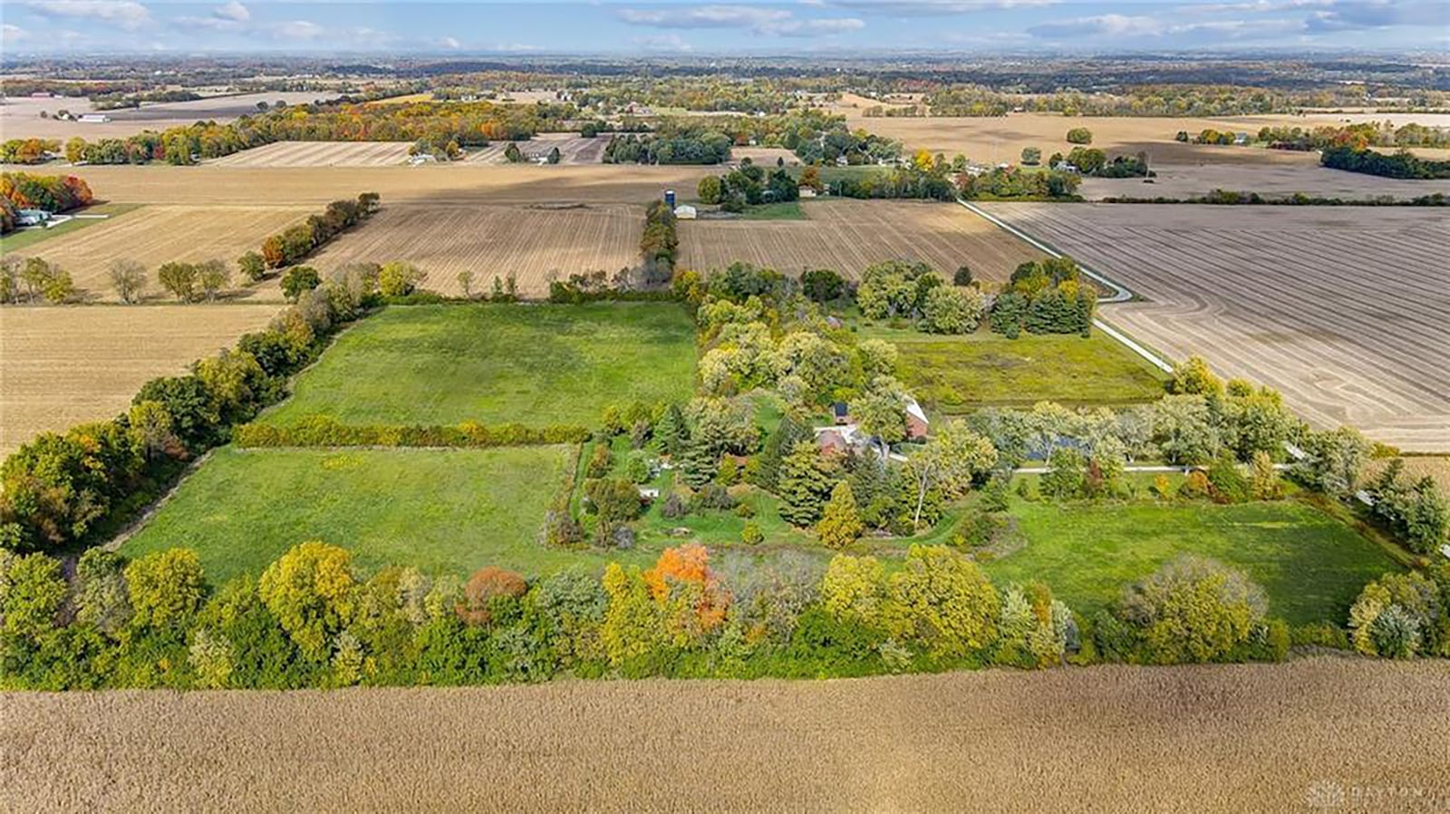 The 20 plus acre lot is surrounded by mature trees and has the original log home, two barns, a garden shed and pond.