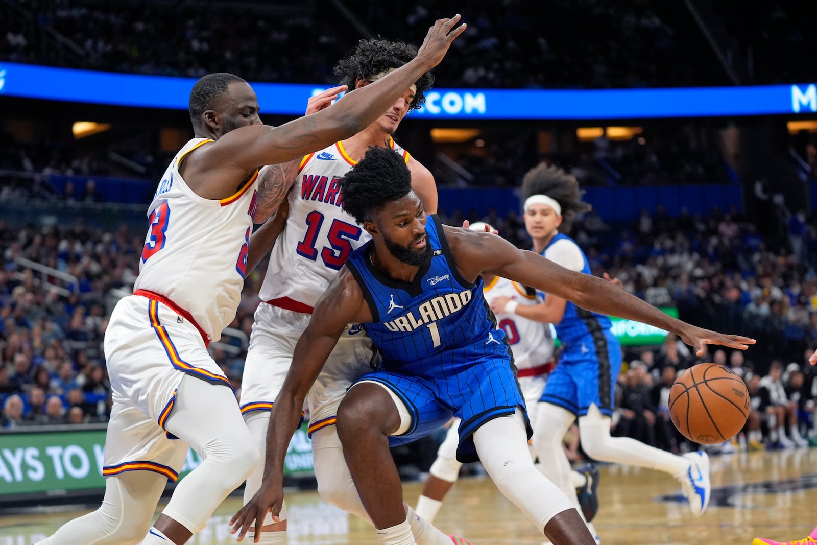 Orlando Magic forward Jonathan Isaac (1) loses control of the ball as his path to the basket is blocked by Golden State Warriors forward Draymond Green, left, and forward Gui Santos (15) during the first half of an NBA basketball game, Thursday, Feb. 27, 2025, in Orlando, Fla. (AP Photo/John Raoux)