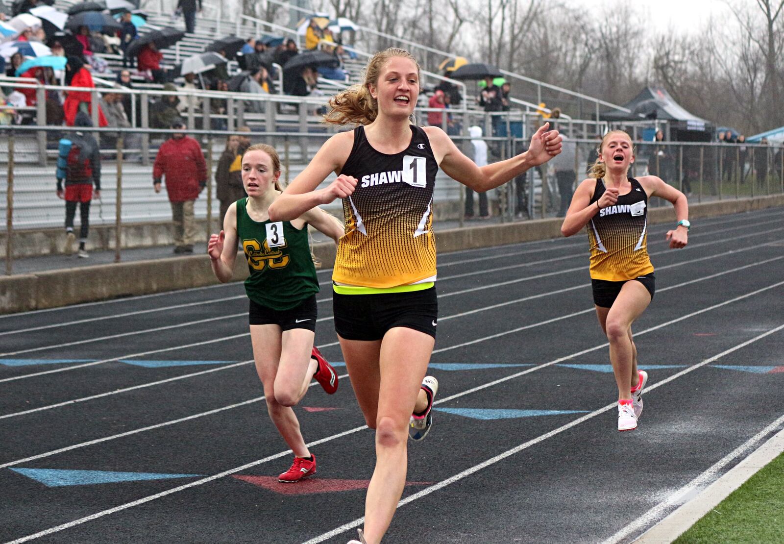 Shawnee’s Grace Holmes wins the 1,600 run ahead of Catholic Central’s Addie Engel (left) and teammate Olivia Warax. Greg Billing / Contributed