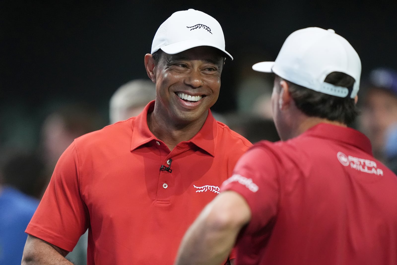 Tiger Woods talks to his Jupiter Links Golf Club teammate Kevin Kisner before the start of a match against the Los Angeles Golf Club, Tuesday, Jan. 14, 2025, in Palm Beach Gardens, Fla. TGL featured two teams of three players competing against each other in a tech-infused arena the size of a football field. (AP Photo/Marta Lavandier)