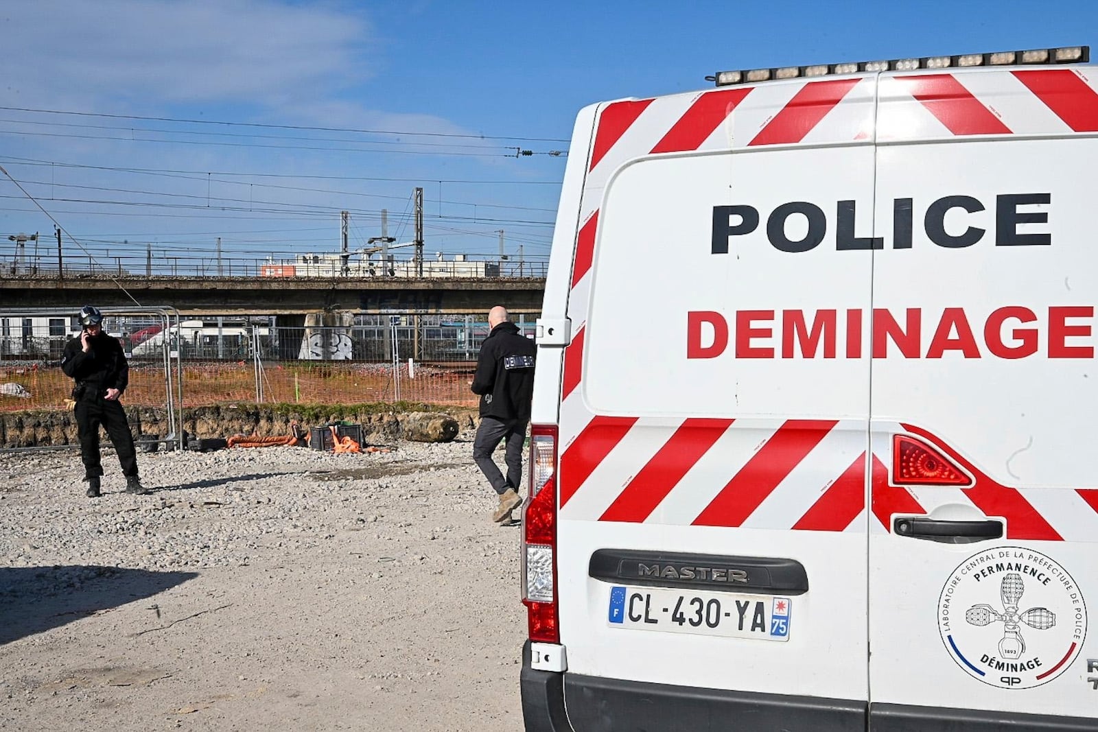 This photo provided by the Paris Police Prefecture shows police disposal officers near a huge unexploded World War II-era bomb that caused transportation chaos in Paris, that included the suspension of high-speed rail links with London and Brussels and the closure of a vital road artery in the French capital Friday, March 7, 2025 in Saint-Denis, outside Paris. (Prefecture de Police via AP)