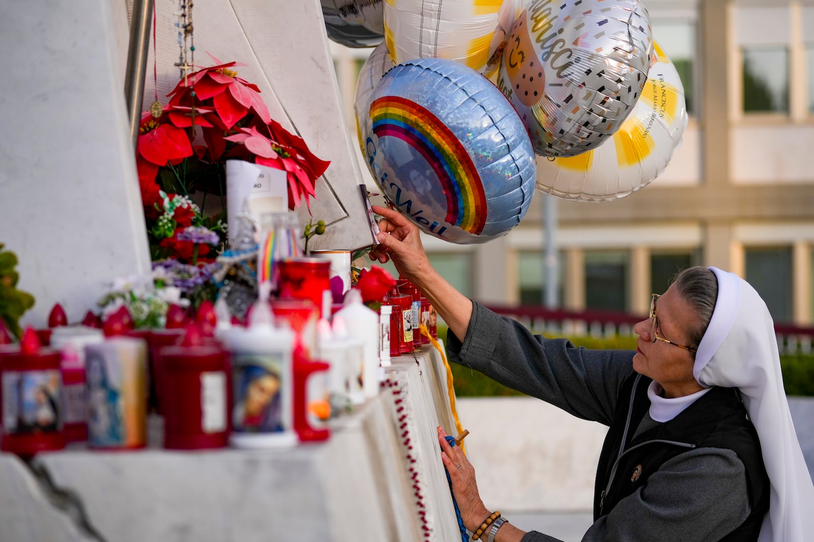 A nuns prays for Pope Francis in front of the Agostino Gemelli Polyclinic, in Rome, Sunday, Feb. 23, 2025, where the Pontiff is hospitalized since Friday, Feb. 14. (AP Photo/Andrew Medichini)