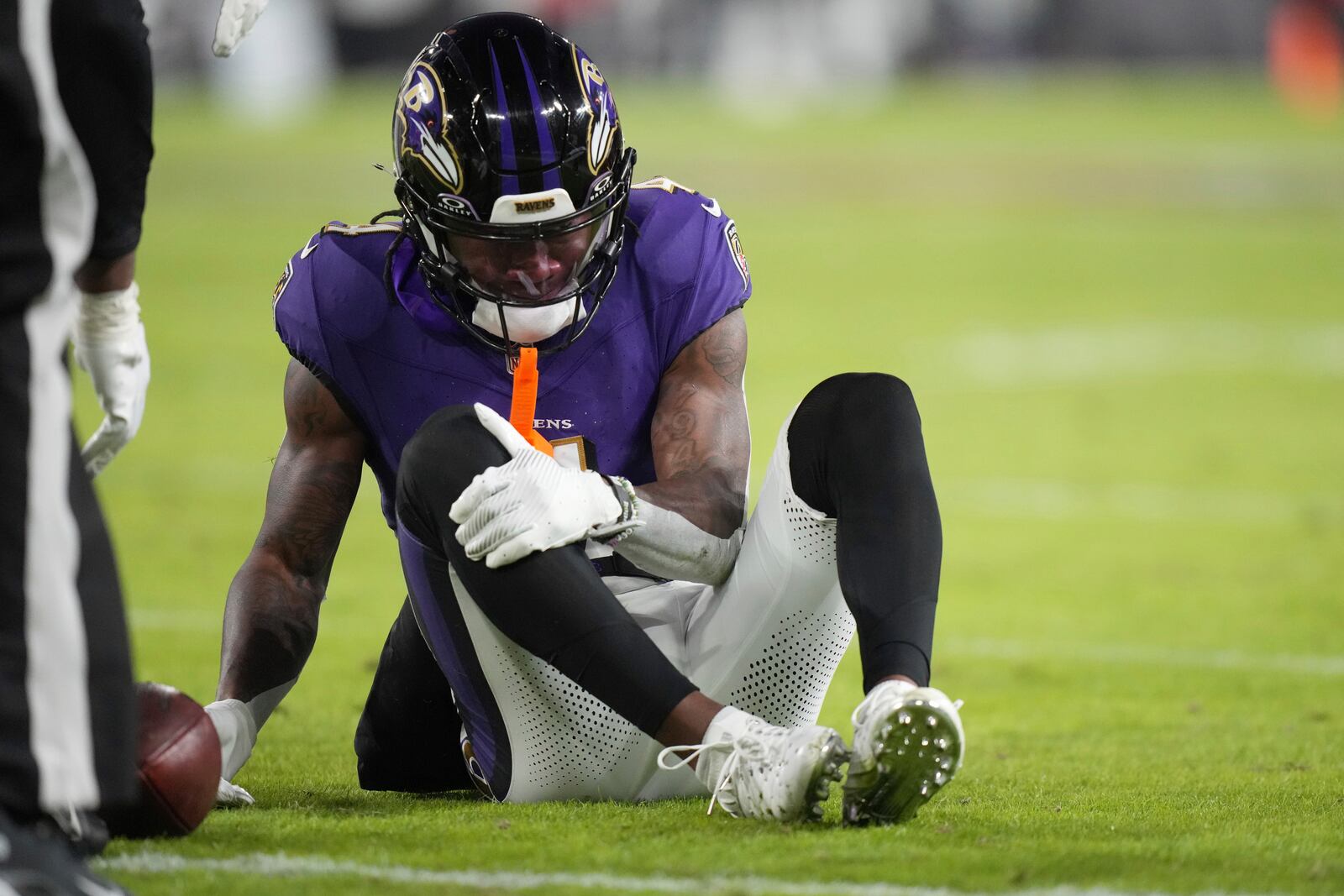 Baltimore Ravens wide receiver Zay Flowers grabs his leg after being injured during the first half of an NFL football game against the Cleveland Browns Saturday, Jan. 4, 2025, in Baltimore. (AP Photo/Stephanie Scarbrough)