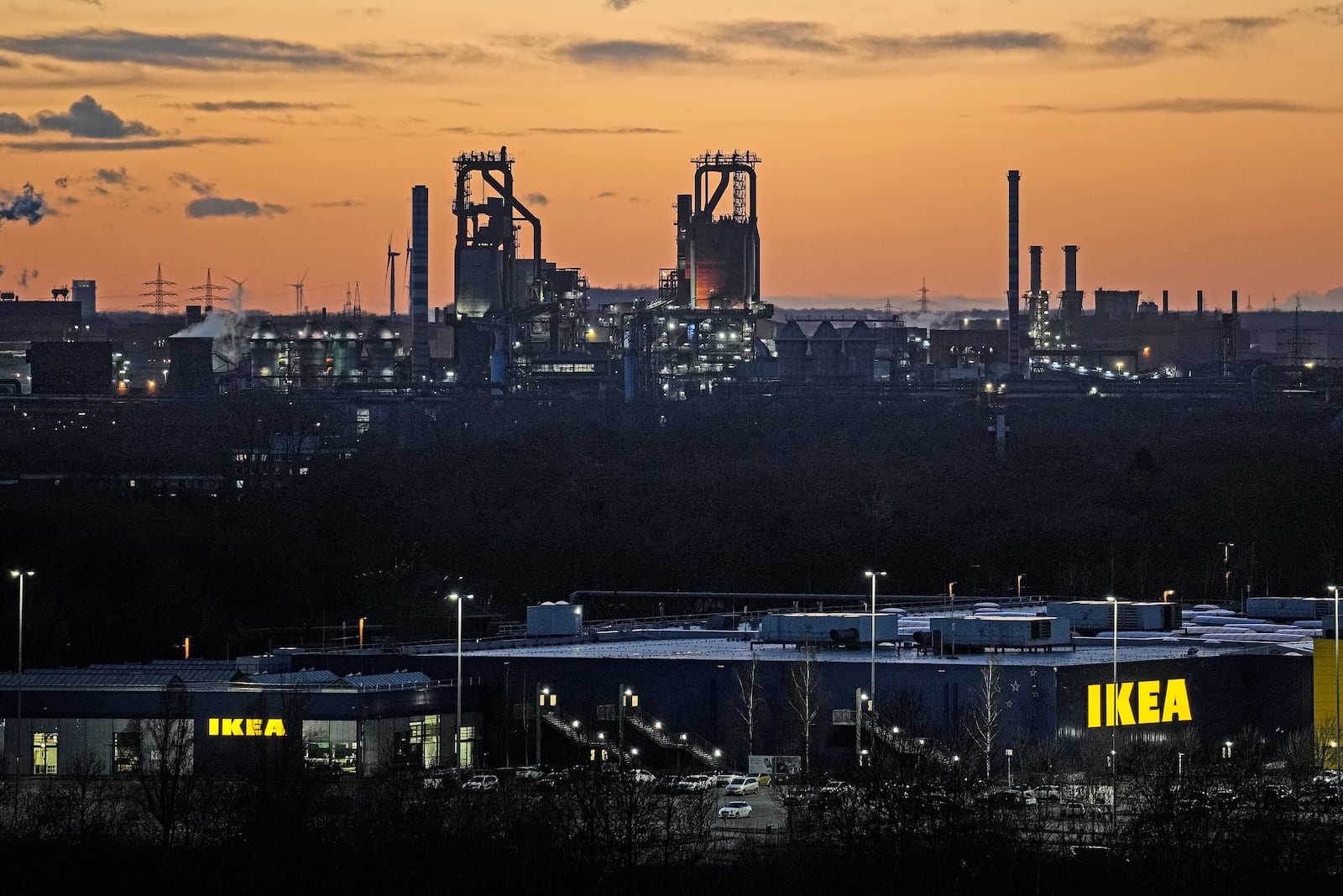 FILE - The blast furnace the troubled thyssenkrupp steel factory is pictured in the evening behind an IKEA store in Duisburg, Germany, Monday, Jan.27, 2025. (AP Photo/Martin Meissner, File)