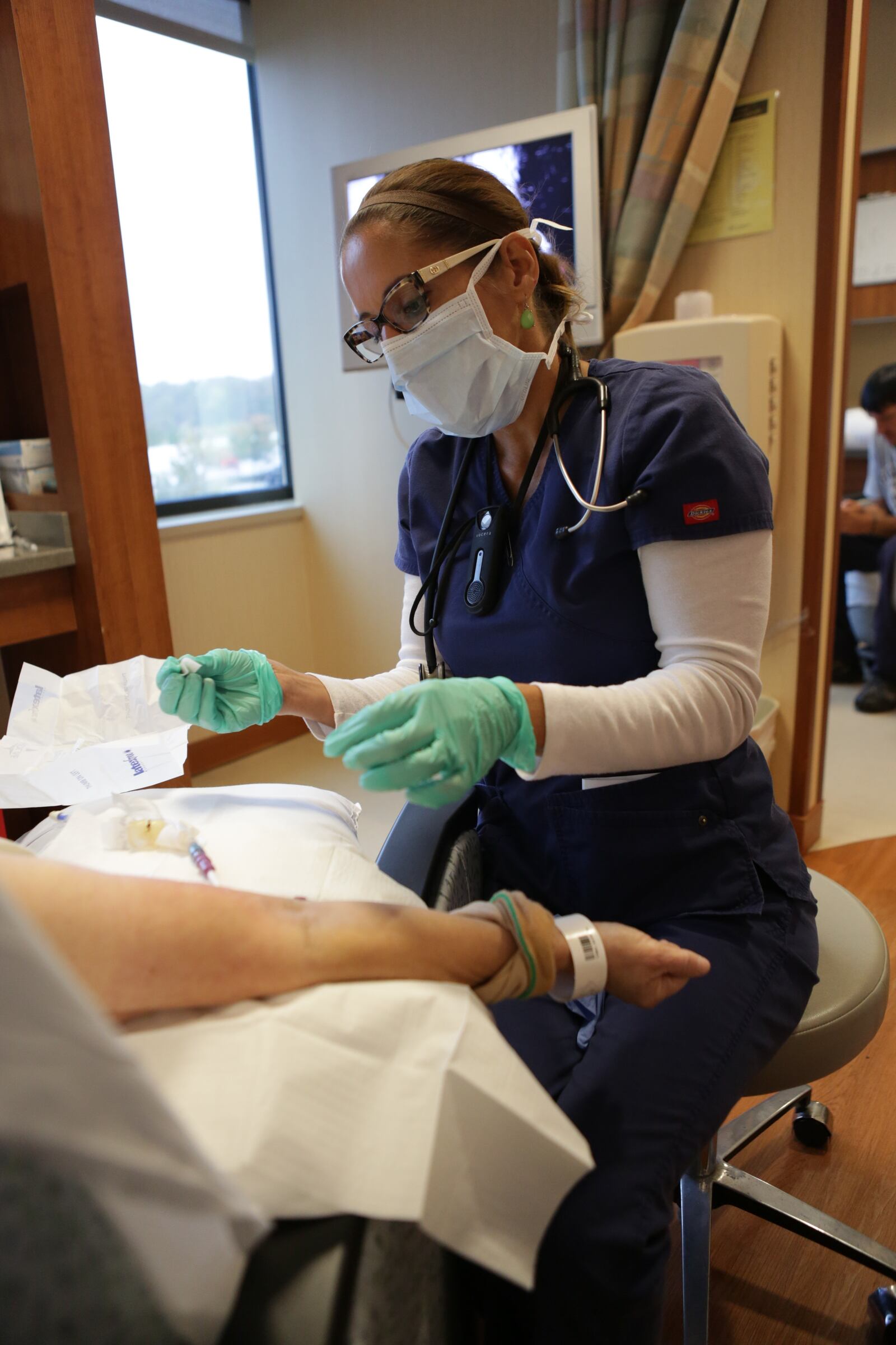 Mary Bowman RN, helps an infusion patient inside the Atrium Medical Center Cancer Center. CONTRIBUTED