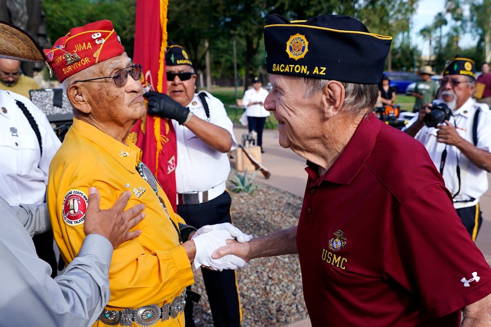 FILE - Navajo Code Talker Thomas Begay, left, shakes hands with Ron Enderle, right, a U.S. Marine veteran from the Korean War era, at the Arizona State Navajo Code Talkers Day ceremony, Aug. 14, 2022, in Phoenix. (AP Photo/Ross D. Franklin, File)