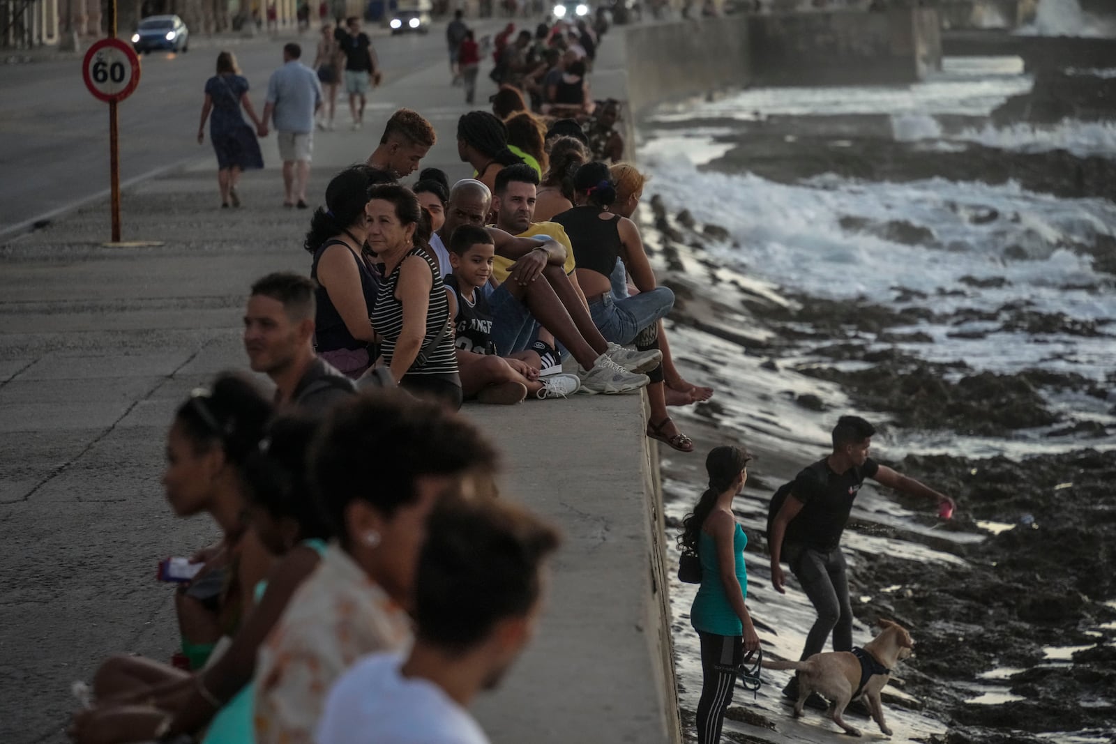 Residents pass the time at the malecon during a blackout following the failure of a major power plant in Havana, Cuba, Sunday, Oct. 20, 2024. (AP Photo/Ramon Espinosa)