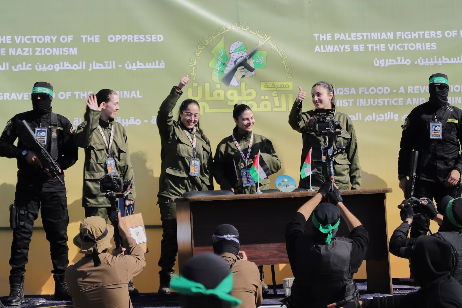 Israeli female soldier hostages wave at a Palestinian crowd before being handed over to the Red Cross in Gaza City, Saturday, Jan. 25, 2025. (AP Photo/Abed Hajjar)