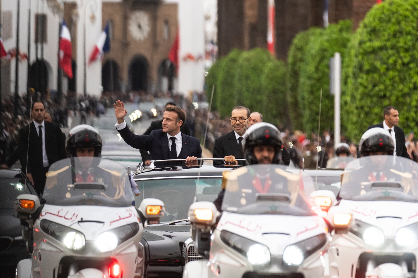 Morocco's king Mohammed VI, right, and French president Emmanuel Macron wave to crowds during the latter's official visit to Morocco, in the capital Rabat, Monday, Oct. 28, 2024. (AP Photo/Mosa'ab Elshamy)