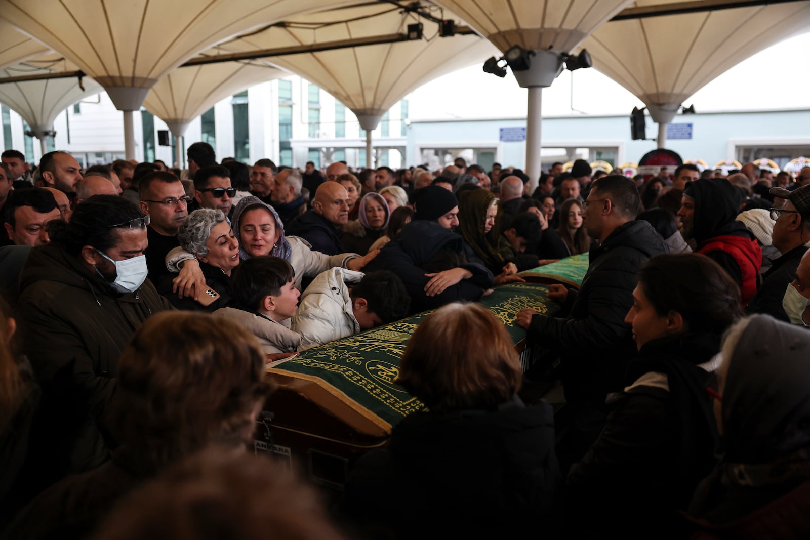 Relatives and friends mourn during the funeral of Yilmaz Saritas and his children Nehir and Doruk, who were among the 76 victims who died in a fire at the Kartalkaya ski resort in Bolu province, at Karsıyaka cemetery in Ankara, Wednesday, Jan. 22, 2025. (Ugur Yildirim/Dia Photo via AP)