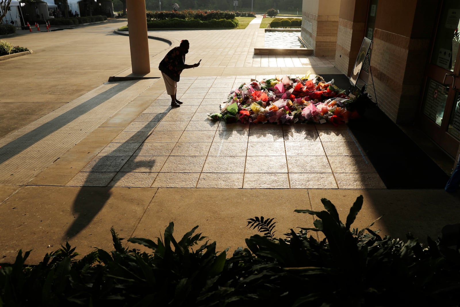 FILE - A woman stops to photograph a memorial for George Floyd at The Fountain of Praise church in Houston, June 9, 2020, in Houston. (AP Photo/Eric Gay, File)