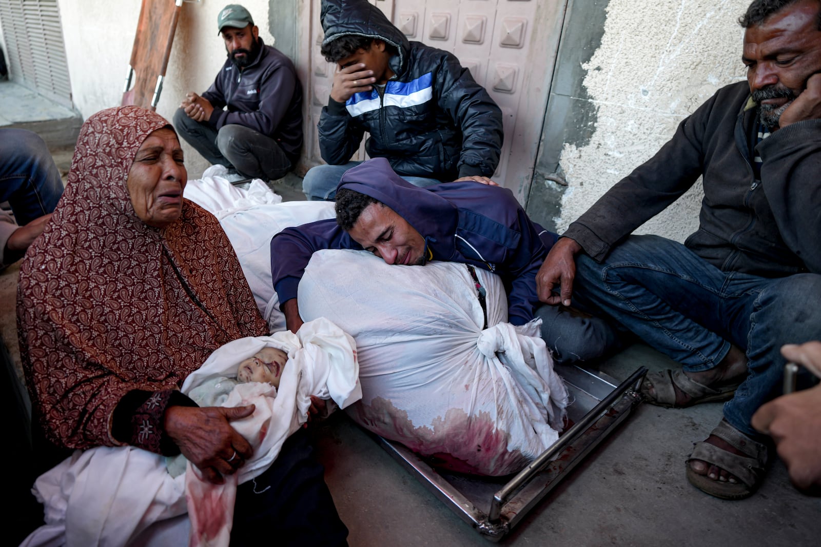 EDS NOTE: GRAPHIC CONTENT - Palestinians mourn their relatives killed in the Israeli bombardment of the Gaza Strip at a hospital morgue in Deir al-Balah, Friday, Nov. 1, 2024. (AP Photo/Abdel Kareem Hana)