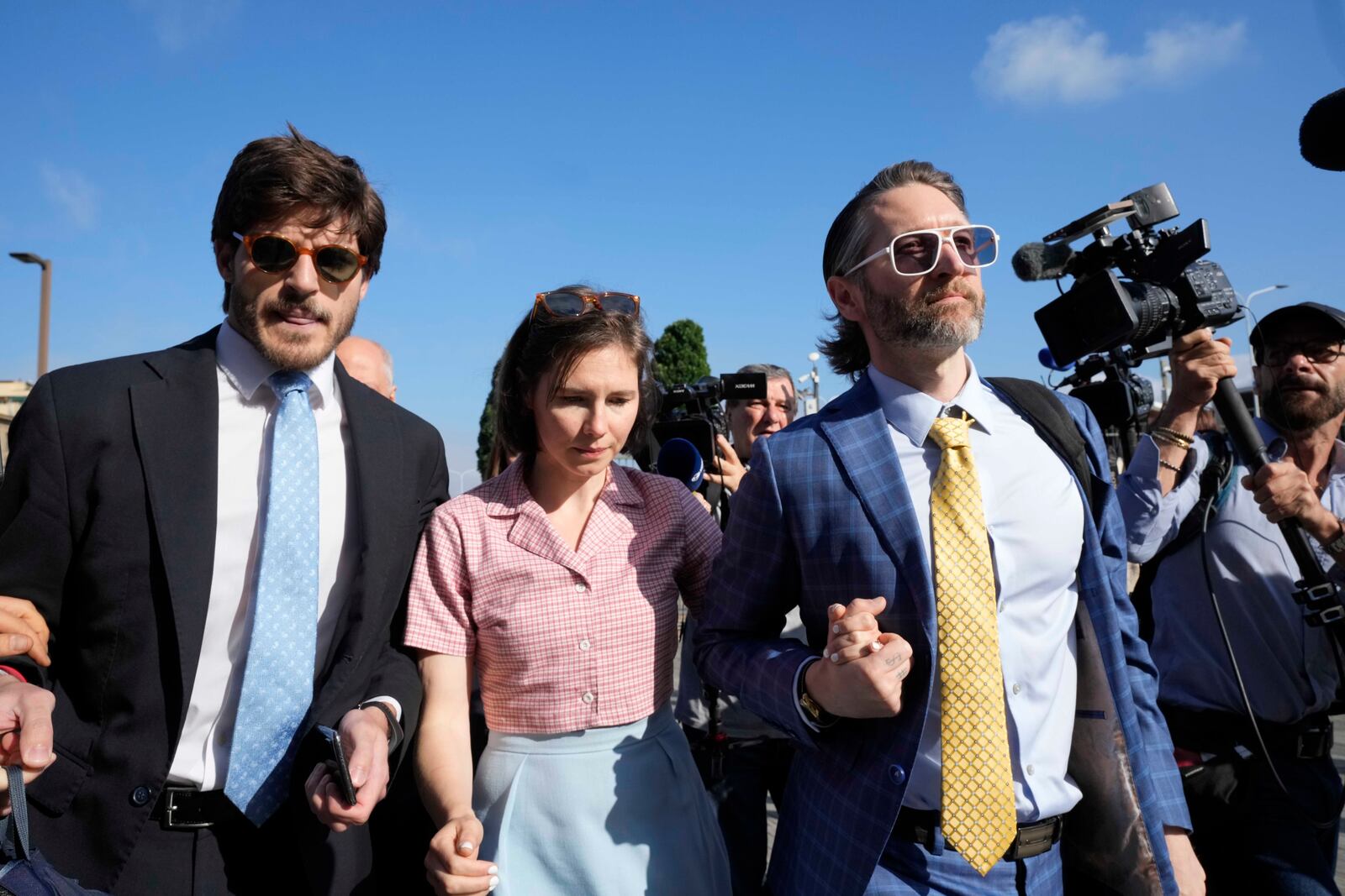 FILE - Amanda Knox arrives flanked by her husband Christopher Robinson, right, and her lawyer Luca Luparia Donati at the Florence courtroom in Florence, Italy, Wednesday, June 5, 2024. (AP Photo/Antonio Calanni, File)