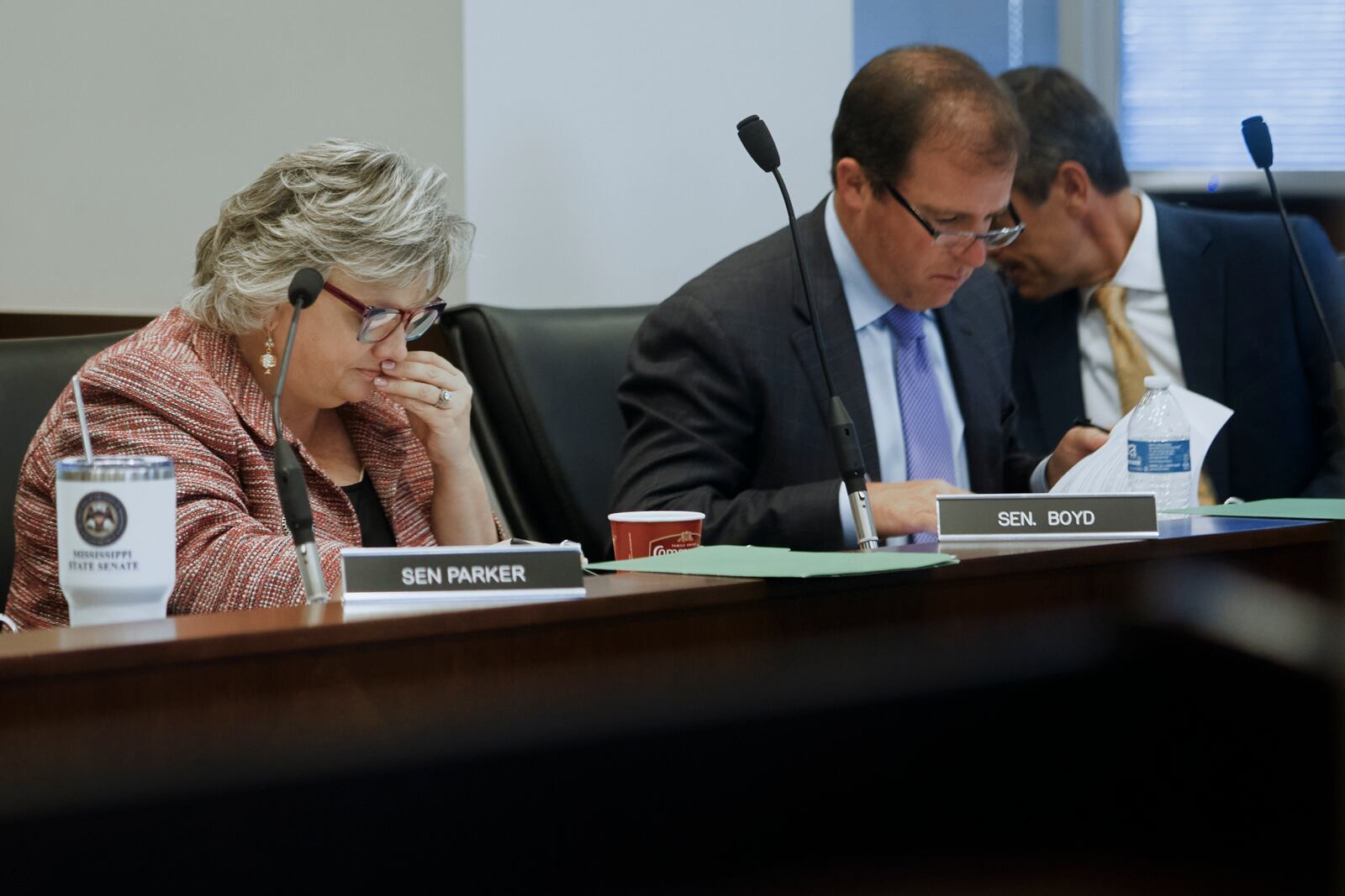 Sen. Nicole Akins Boyd, R-Oxford, left, listens during a Mississippi Joint Legislative Budget Committee meeting as state Sen. Josh Harkins, R-Flowood, talks with Sen. Briggs Hopson, R-Vicksburg, at the Woolfolk state office building Sept. 26, 2024, in Jackson, Miss. (AP Photo/Justin Hardiman)