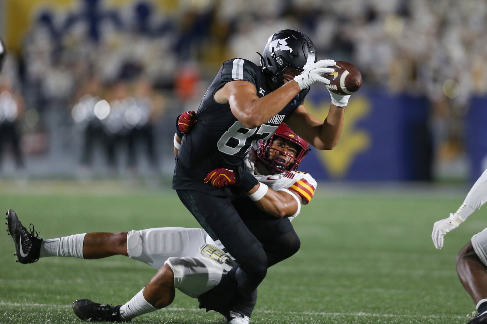 West Virginia tight end Kole Taylor (87) makes a catch and tackled by Iowa State linebacker Jacob Ellis (44) during the first half of an NCAA college football game, Saturday, Oct. 12, 2024, in Morgantown, W.Va. (AP Photo/William Wotring)