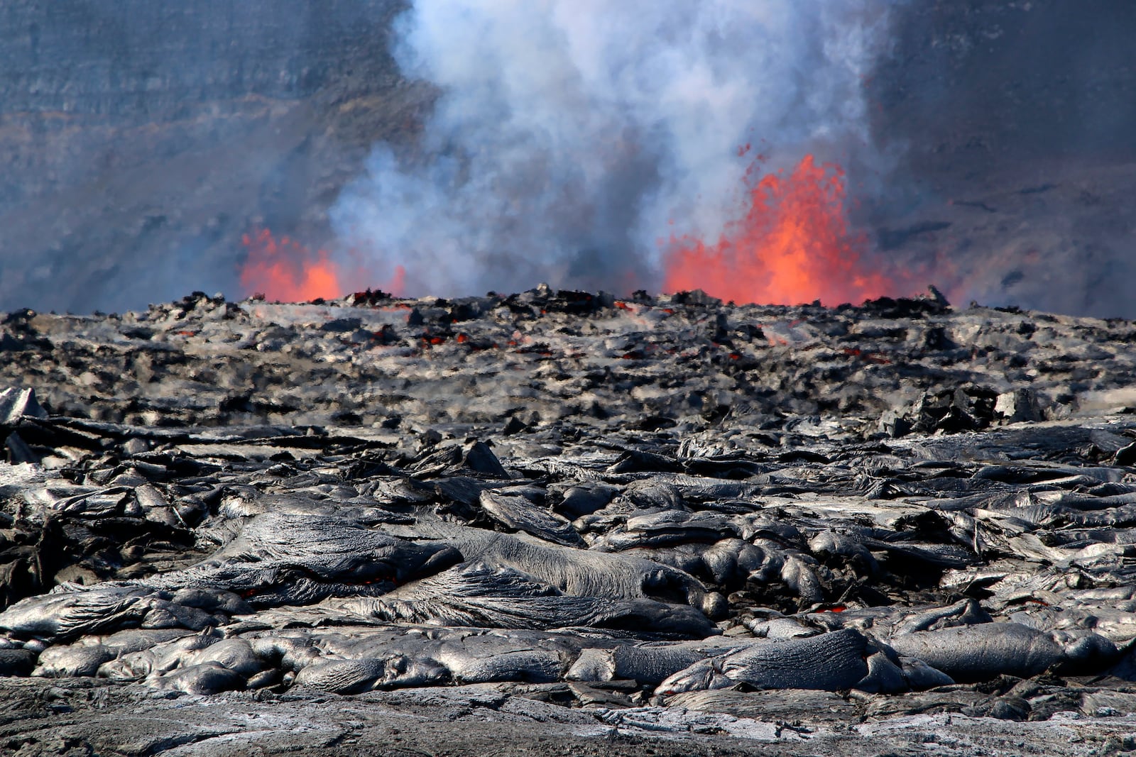 During the Kīlauea summit eruption's eighth episode, shows two eruptive vents actively fountaining from the floor of Haleumaumau Crater as newly emplaced lava flows exhibit intense heat shimmer and residual glow in some of their cracks at the summit of Kilauea volcano inside Hawaii Volcanoes National Park, Hawaii. Tuesday, Feb. 4, 2025. (M. Zoeller/U.S. Geological Survey via AP)