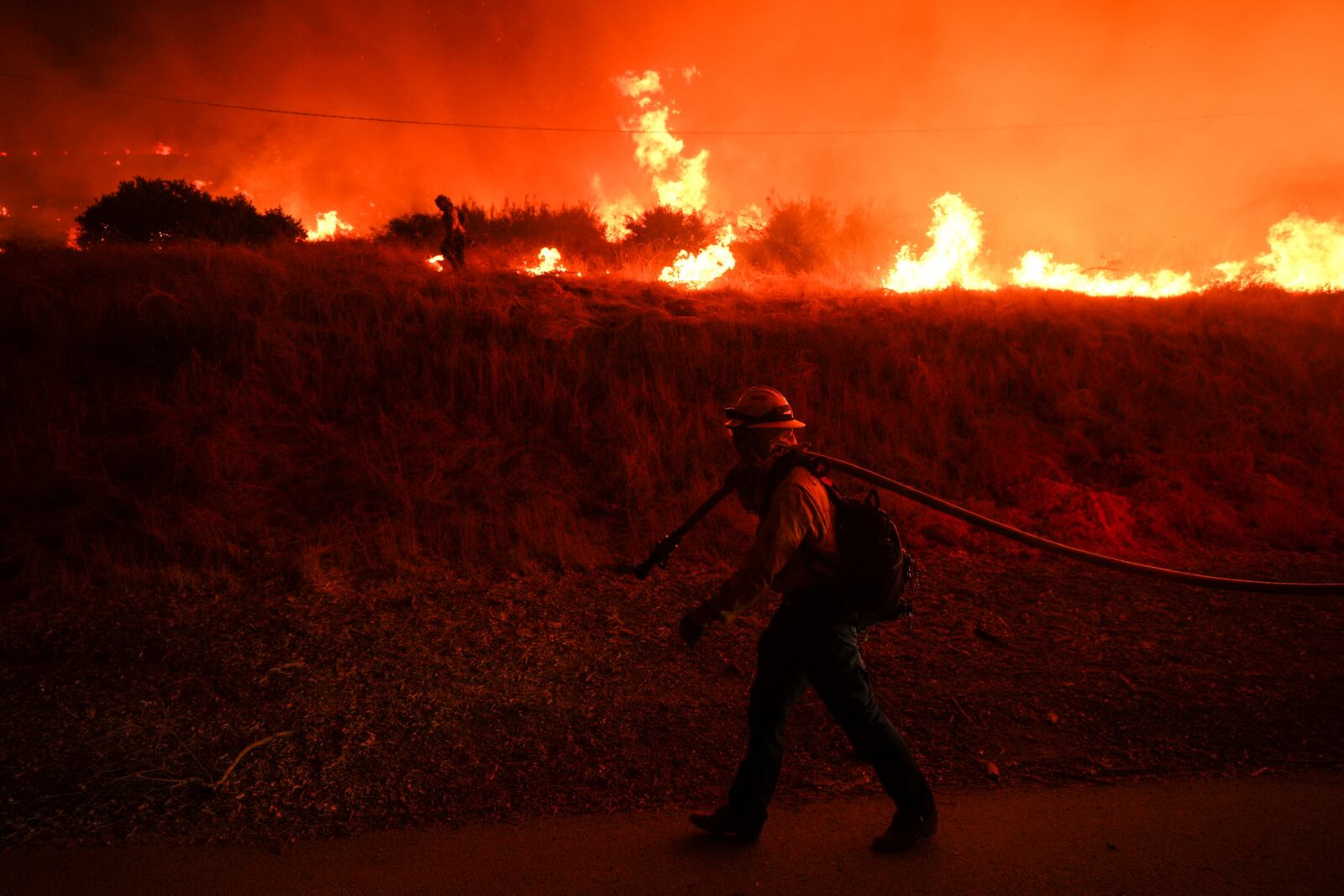 FILE - A firefighter monitors flames caused by the Hughes Fire along Castaic Lake in Castaic, Calif., Jan. 22, 2025. (AP Photo/Jae C. Hong, File)