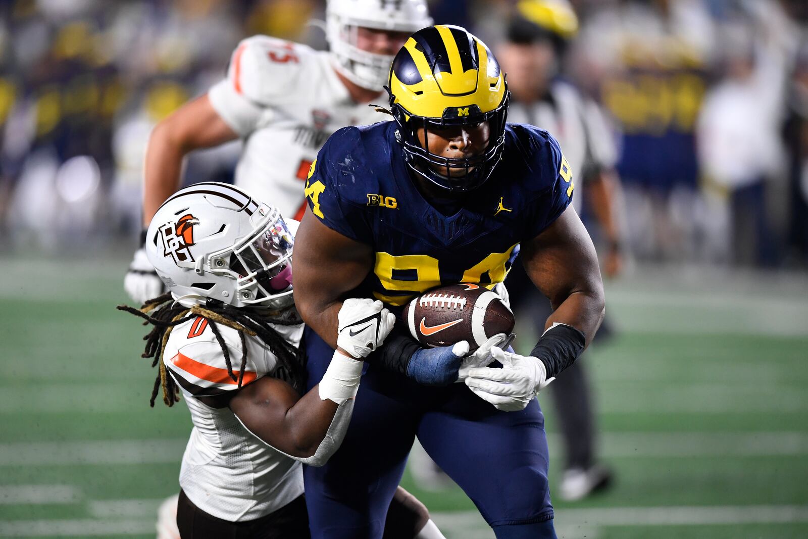 Michigan defensive lineman Kris Jenkins, right, returns an interception as he is tackled by Bowling Green linebacker Cashius Howell in the second half of an NCAA college football game, Saturday, Sept. 16, 2023, in Ann Arbor, Mich. (AP Photo/Jose Juarez)