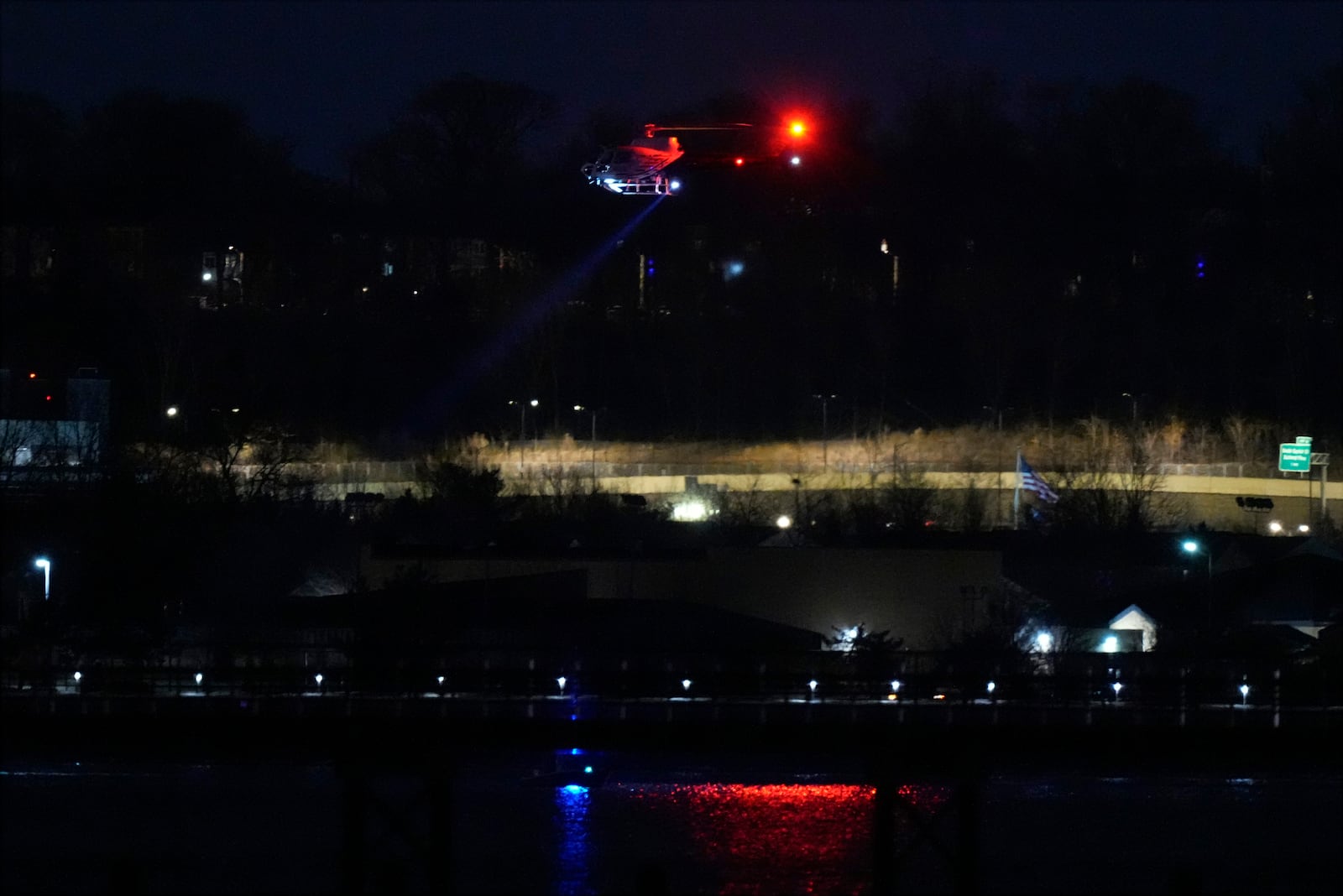 A helicopter uses its searchlight as it flies above the Potomac River near Ronald Reagan Washington National Airport Wednesday, Jan. 29, 2025, in Arlington, Va. (AP Photo/Alex Brandon)