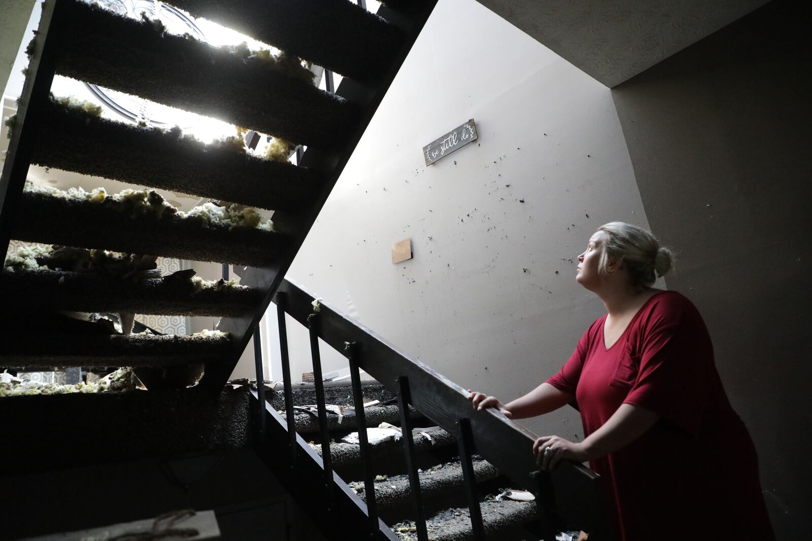 Sunlight floods through holes in the roof as Saddie Acles looks up at what’s left of the second floor of her townhouse apartment where she and her family were rescued by members of the Springfield Fire Division during a fire early Tuesday morning. BILL LACKEY/STAFF